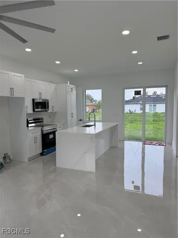 a large kitchen with stainless steel appliances kitchen island a large counter top