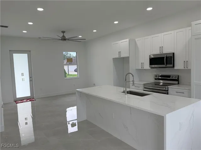a kitchen with sink a microwave and refrigerator