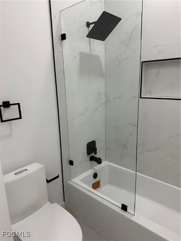 a white toilet sitting next to a bath tub