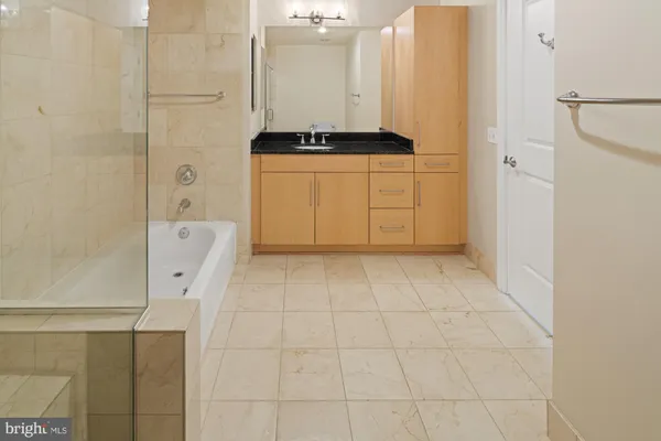 a bathroom with a granite countertop sink a toilet a mirror and shower