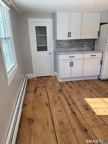a view of a kitchen with a sink and wooden floor