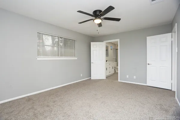 an empty room with a window and a fan