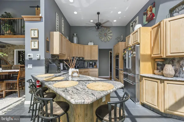 a kitchen with stainless steel appliances granite countertop a stove a sink and a refrigerator