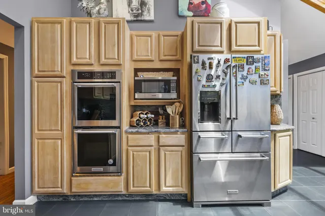 a dining area with stainless steel appliances kitchen island granite countertop a dining table and chairs