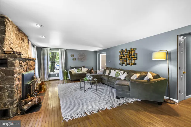 a living room with furniture a large window and a fireplace