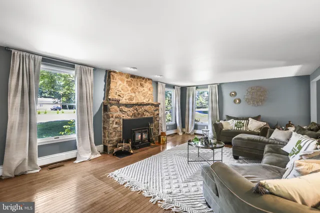 a living room with couches fireplace and a large window with garden view