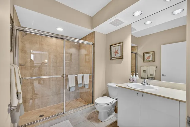 a bathroom with a toilet a sink and glass door