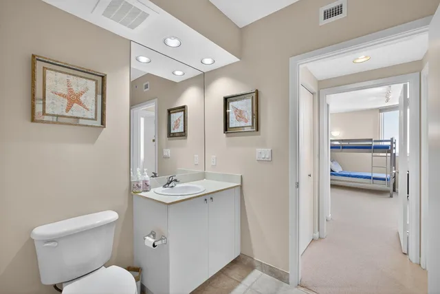 a bathroom with a granite countertop toilet sink and mirror