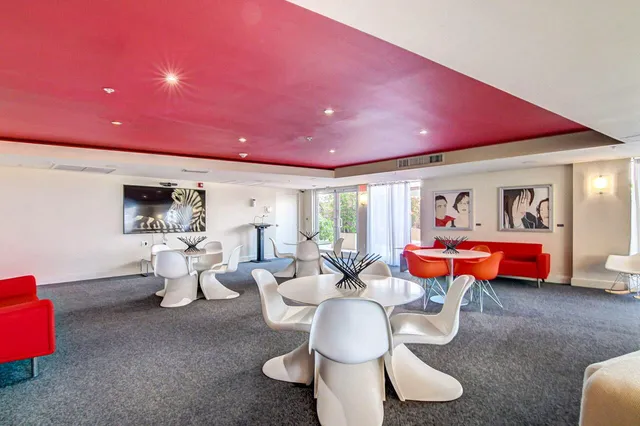 a living room with furniture a pool table and chairs