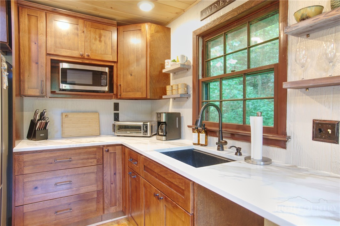 9440 Blackberry Road Lenoir, NC 28645 - Photo 9 of 30 a kitchen with granite countertop a sink and a stove next to a window
