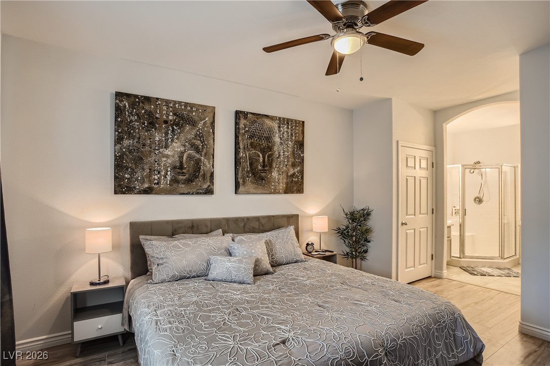 7701 West Robindale Road, Unit 149 Las Vegas, NV 89113 - Photo 11 of 22 Bedroom with wood finished floors, connected bathroom, ceiling fan, and arched walkways