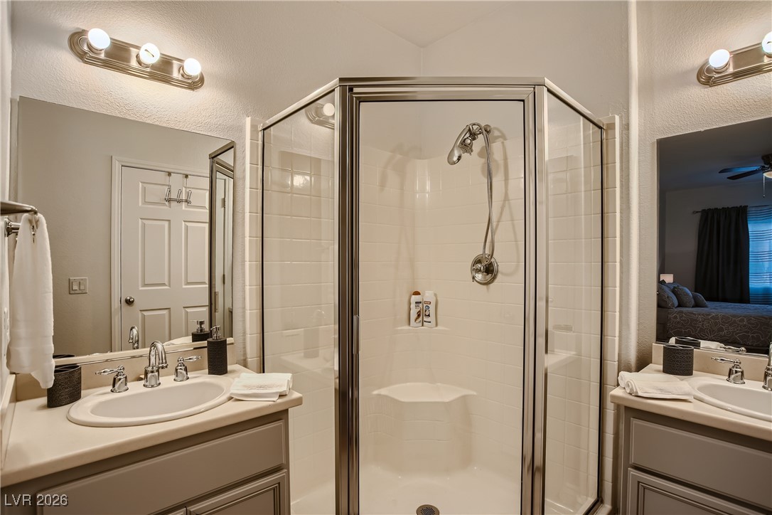 7701 West Robindale Road, Unit 149 Las Vegas, NV 89113 - Photo 13 of 22 Ensuite bathroom with two vanities, a shower stall, and ceiling fan