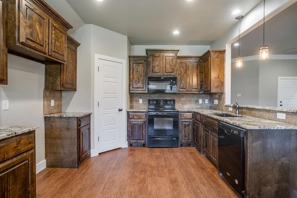 110 Hummingbird Drive Weatherford, TX 76085 - Photo 13 of 38 a kitchen with stainless steel appliances granite countertop a refrigerator a stove top oven a sink and dishwasher