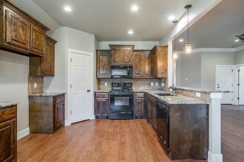 110 Hummingbird Drive Weatherford, TX 76085 - Photo 14 of 38 a kitchen with granite countertop a stove top oven and refrigerator
