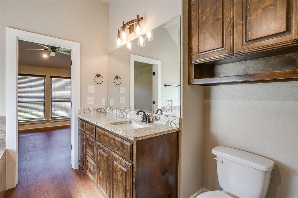 110 Hummingbird Drive Weatherford, TX 76085 - Photo 26 of 38 a bathroom with a sink a toilet and vanity