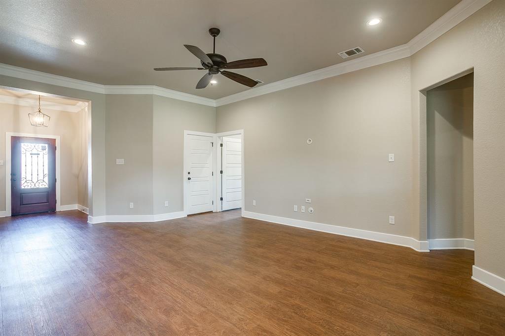 110 Hummingbird Drive Weatherford, TX 76085 - Photo 3 of 38 a view of an empty room with wooden floor and a ceiling fan
