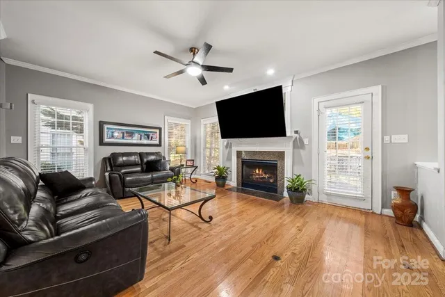 a living room with furniture a fireplace a flat screen tv and wooden floor