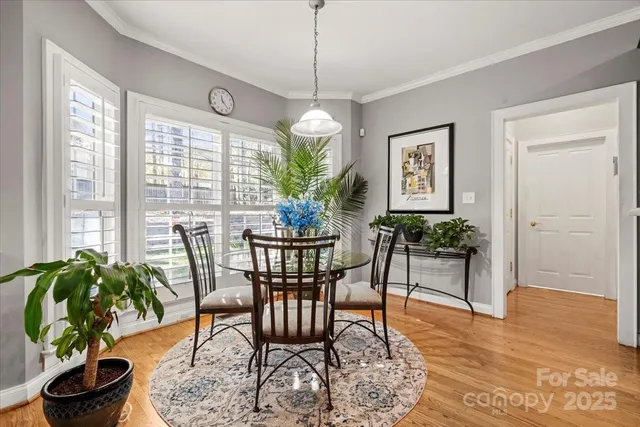 a dining room with furniture potted plants and wooden floor