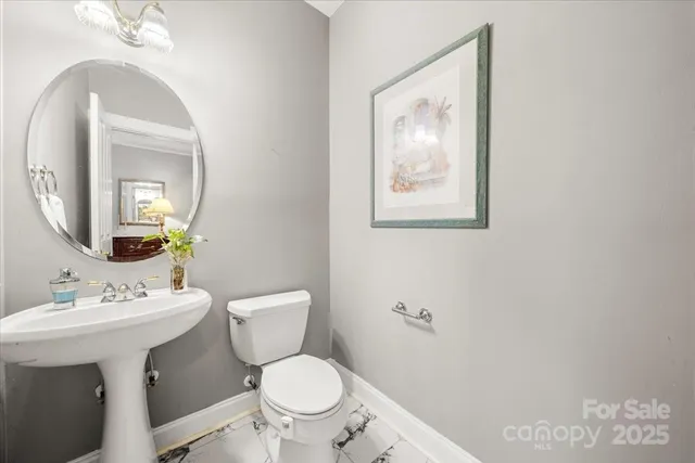 a bathroom with a toilet a sink and mirror