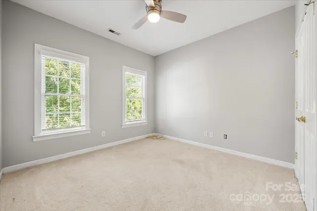 an empty room with a window and a fan