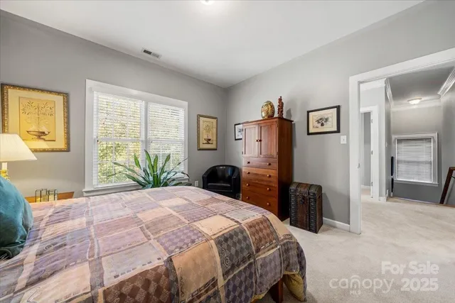 a bedroom with a large bed and large windows