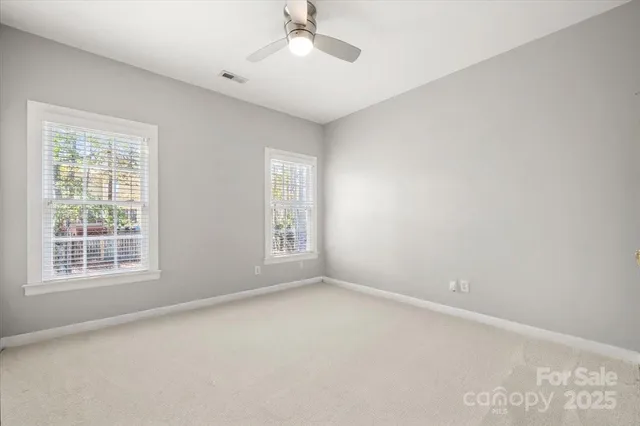an empty room with a window and a ceiling fan