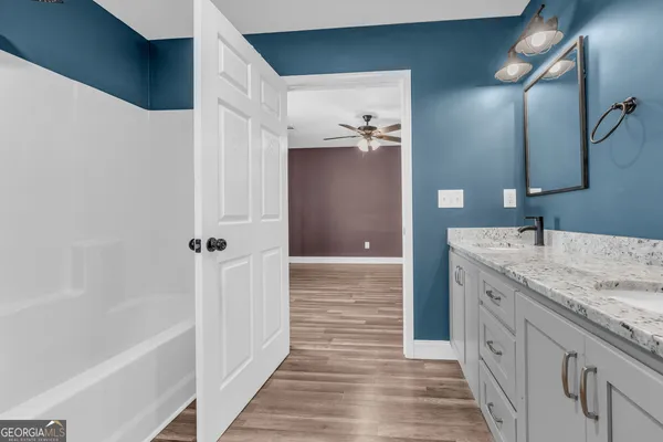 a bathroom with a granite countertop sink a mirror and a bathtub
