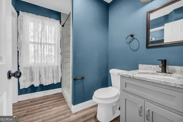a bathroom with a granite countertop sink toilet and shower