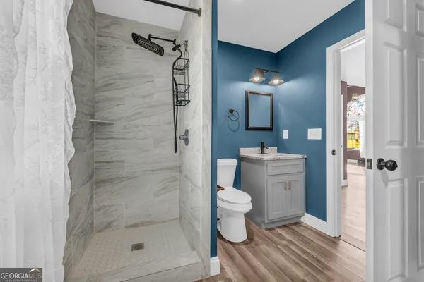 a bathroom with a shower a toilet and a sink