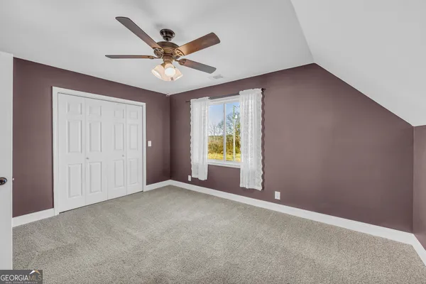 an empty room with window and ceiling fan