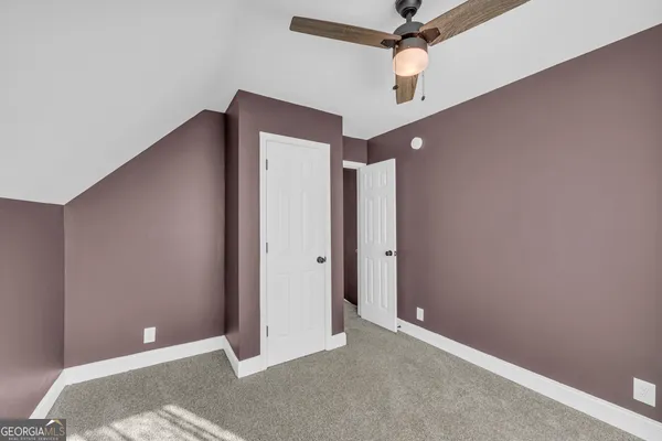 a view of a hallway with a chandelier fan