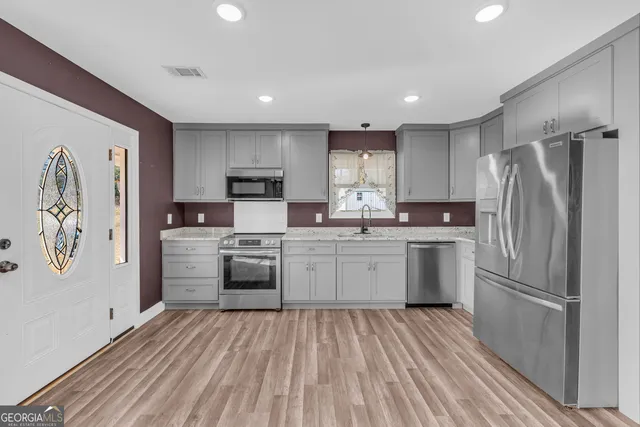 a view of an empty room with window and wooden floor