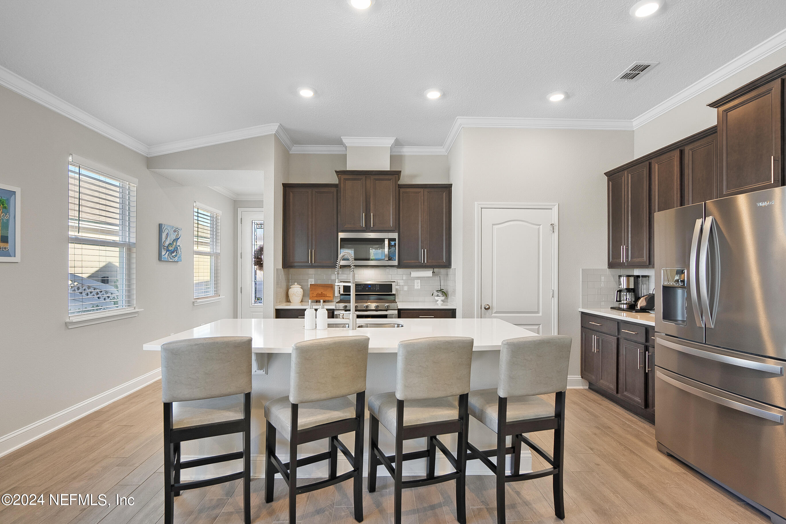 62 Thistleton Way Street St. Augustine, FL 32092 - Photo 11 of 29 a kitchen with stainless steel appliances kitchen island granite countertop a refrigerator and microwave