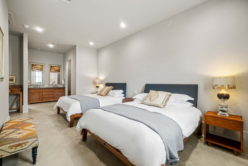 371 Achtzehn Road Fredericksburg, TX 78624 - Photo 37 of 41 a spacious bedroom with two beds and painted walls