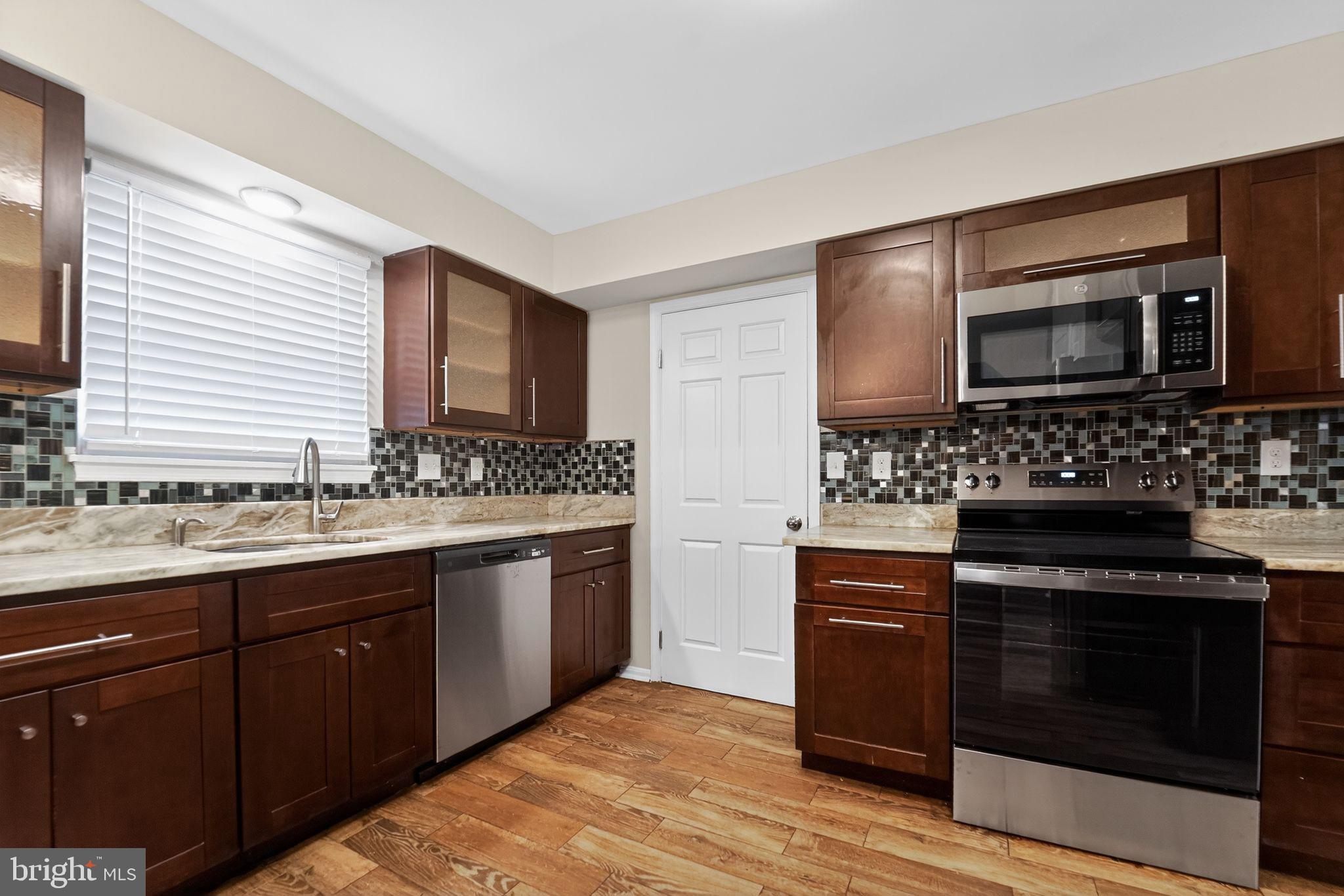 5904 Mardella Boulevard Clinton, MD 20735 - Photo 18 of 34 a kitchen with stainless steel appliances a stove sink and microwave