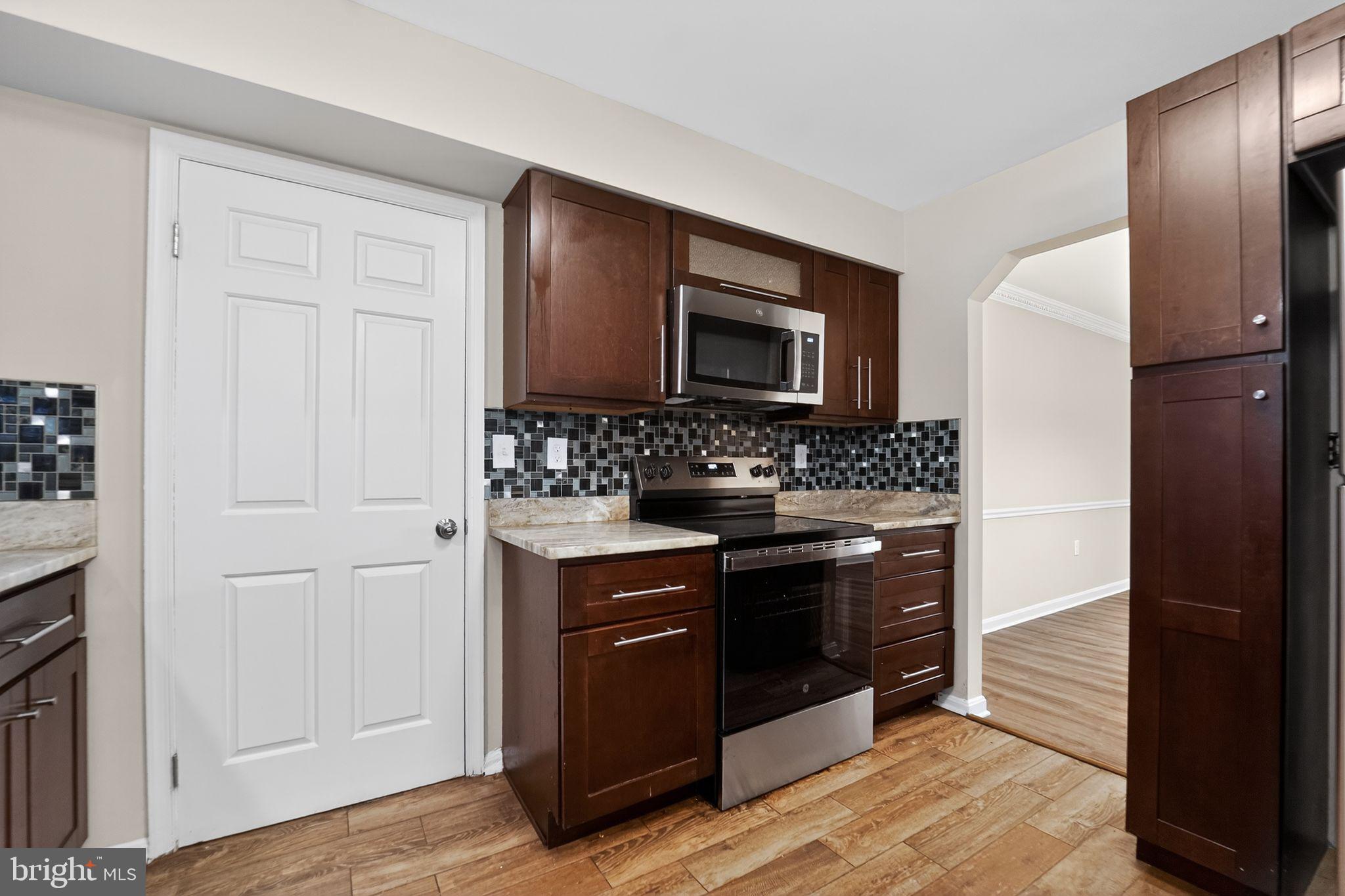 5904 Mardella Boulevard Clinton, MD 20735 - Photo 20 of 34 a kitchen with stainless steel appliances granite countertop a stove and a refrigerator