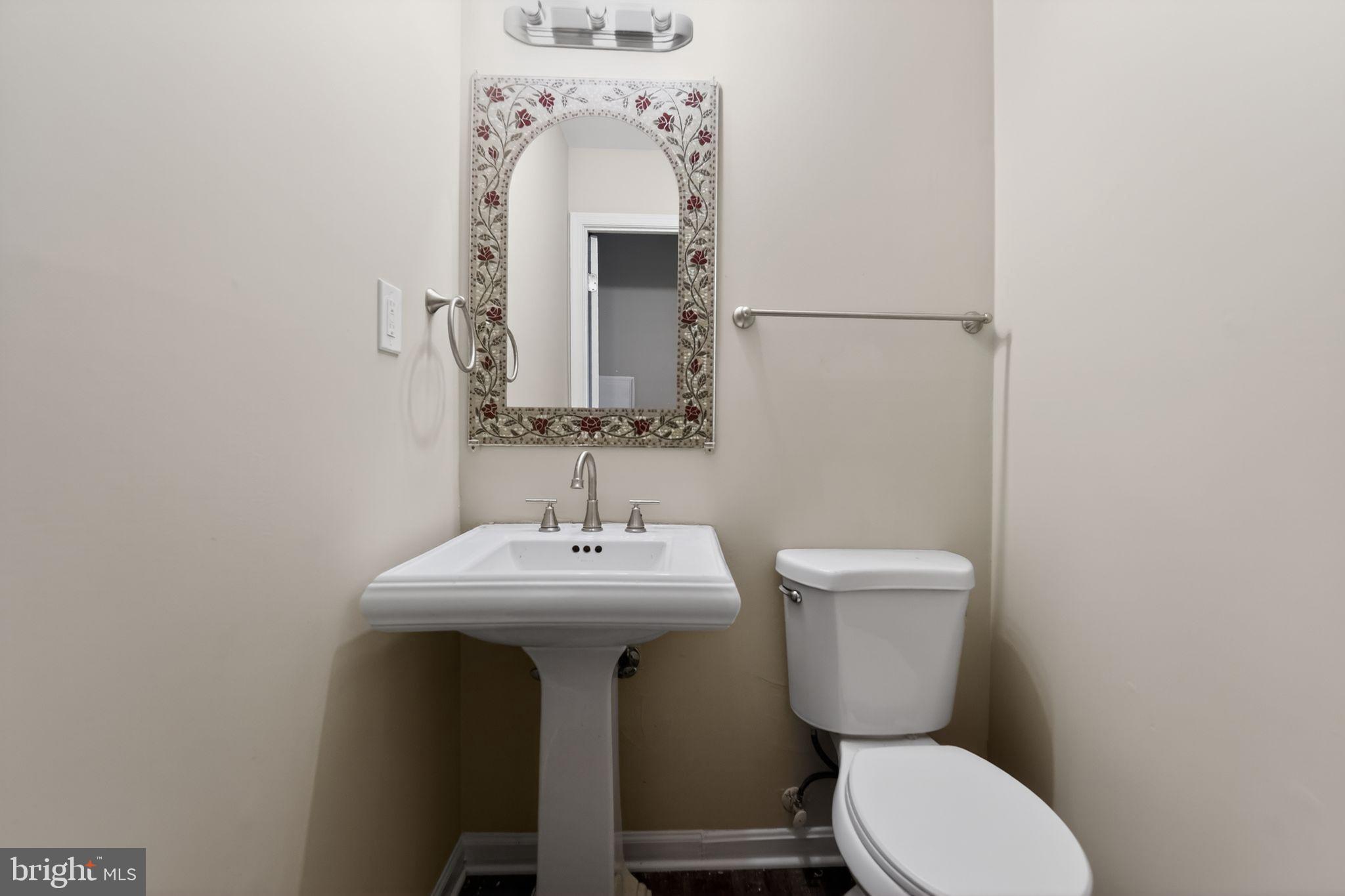 5904 Mardella Boulevard Clinton, MD 20735 - Photo 25 of 34 a bathroom with a toilet a sink and mirror