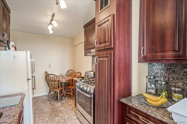 a kitchen with stainless steel appliances granite countertop a refrigerator and a sink