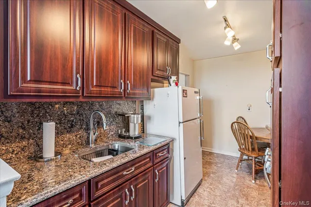 a kitchen with stainless steel appliances granite countertop a stove a refrigerator and a wooden cabinets