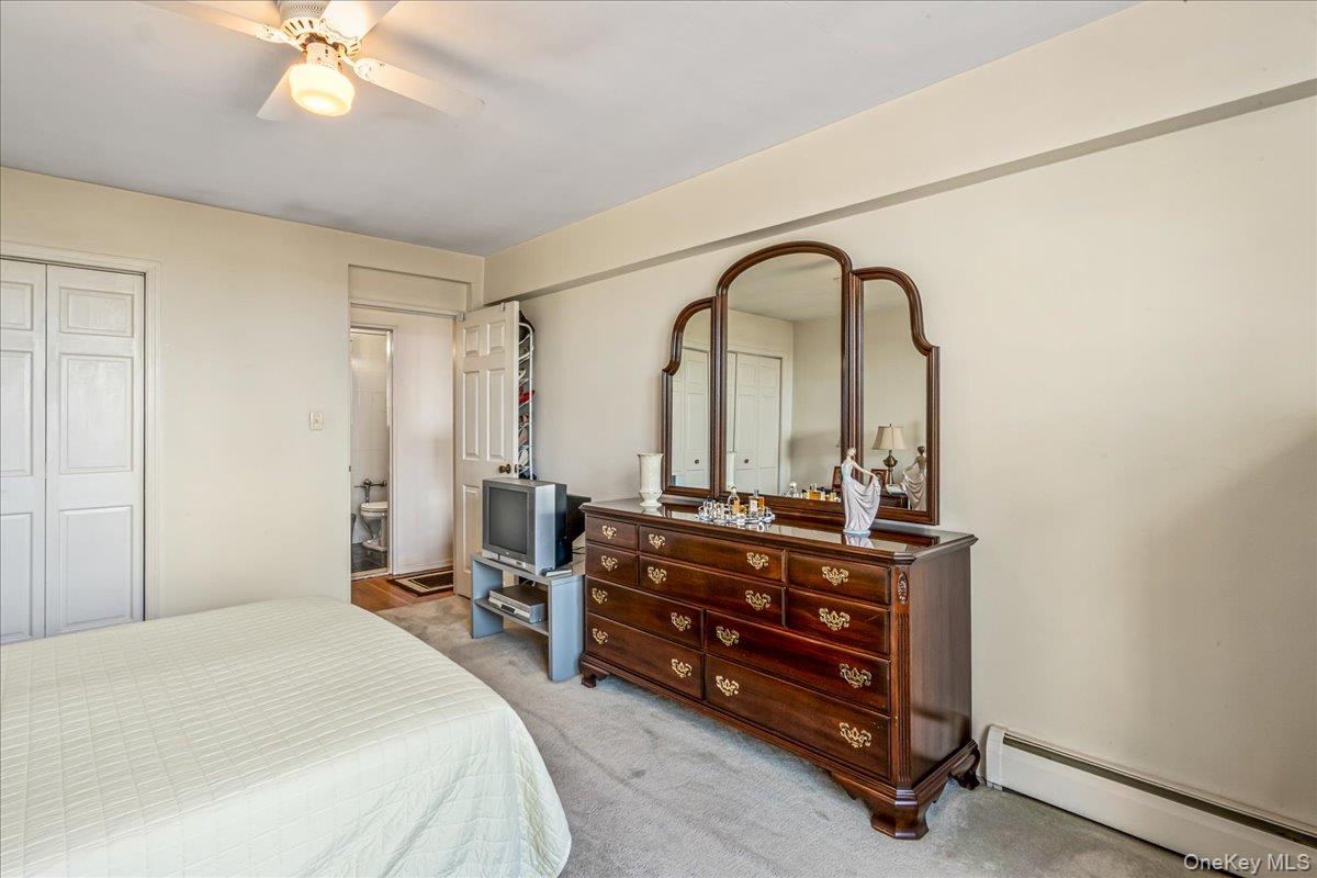 151-05 Cross Island Parkway, Unit 6C Queens, NY 11357 - Photo 17 of 20 a bedroom with a bed and a chandelier