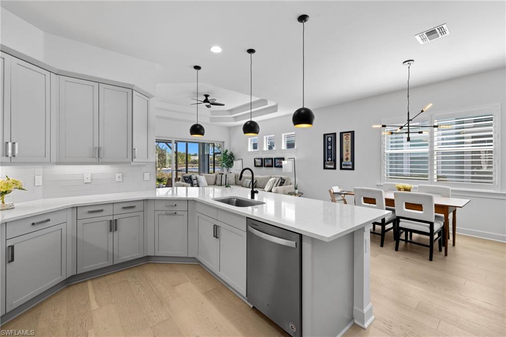 6291 Arriba Avenue Naples, FL 34113 - Photo 9 of 43 a open kitchen with stainless steel appliances granite countertop a sink and dishwasher a oven with wooden cabinets