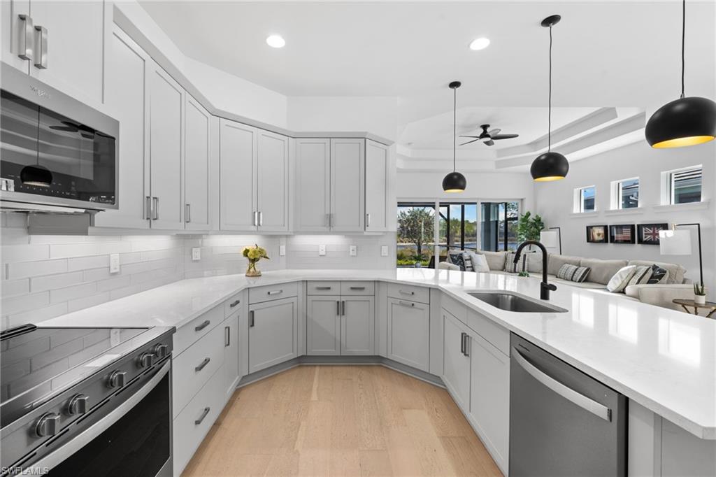 6291 Arriba Avenue Naples, FL 34113 - Photo 42 of 43 a kitchen with a sink stove and cabinets