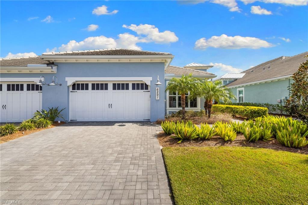 6291 Arriba Avenue Naples, FL 34113 - Photo 18 of 43 a front view of a house with a yard