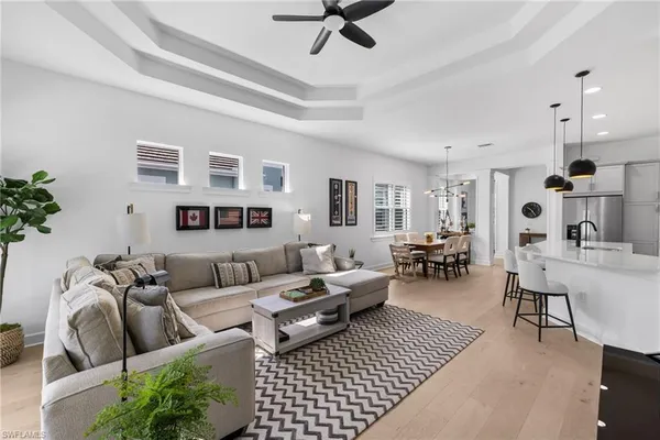 a living room with furniture a flat screen tv and kitchen view