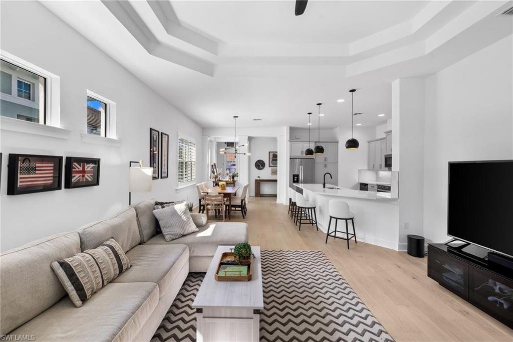 6291 Arriba Avenue Naples, FL 34113 - Photo 41 of 43 a living room with furniture a flat screen tv and kitchen view