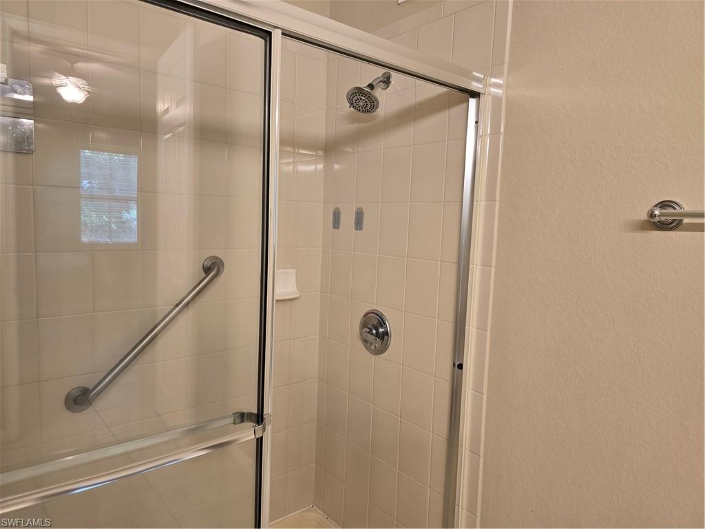 1020 Peggy Circle, Unit 101 Naples, FL 34113 - Photo 16 of 30 a bathroom with a glass shower door
