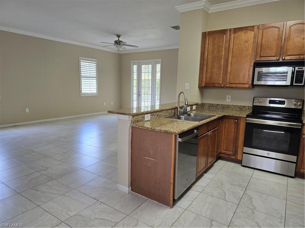 1020 Peggy Circle, Unit 101 Naples, FL 34113 - Photo 6 of 30 a kitchen with stainless steel appliances granite countertop a stove a sink and a microwave