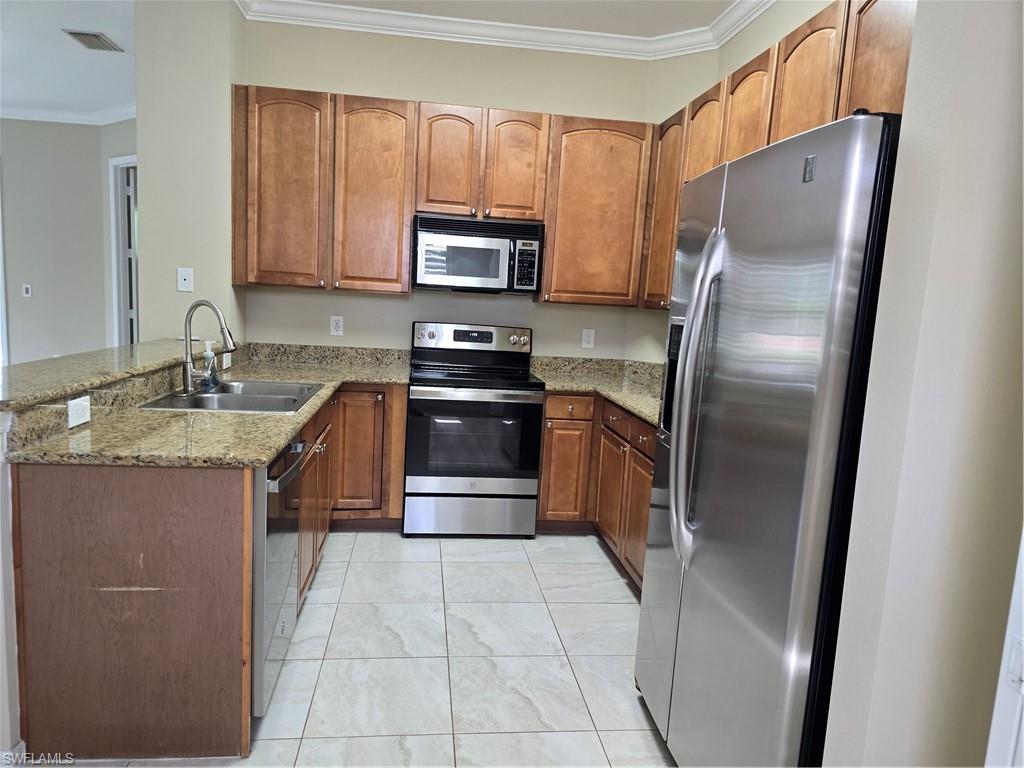 1020 Peggy Circle, Unit 101 Naples, FL 34113 - Photo 7 of 30 a kitchen with stainless steel appliances granite countertop a refrigerator stove and sink