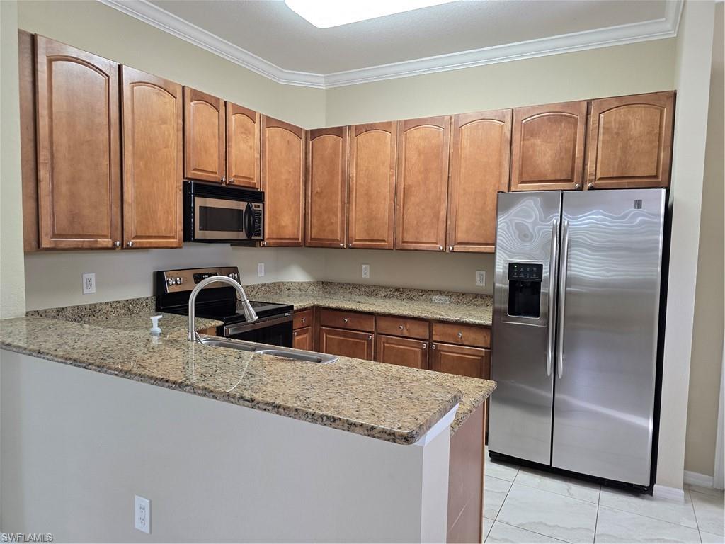 1020 Peggy Circle, Unit 101 Naples, FL 34113 - Photo 8 of 30 a kitchen with granite countertop stainless steel appliances a refrigerator a stove a sink cabinets and a counter space