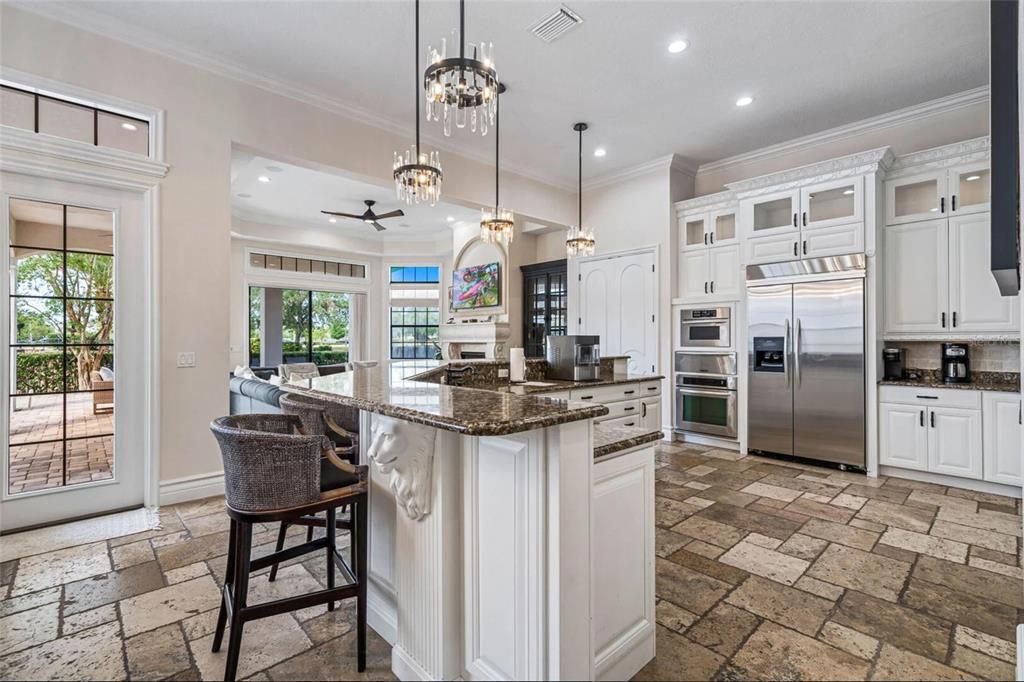 304 Muirfield Loop Reunion, FL 34747 - Photo 15 of 85 a kitchen with stainless steel appliances kitchen island granite countertop a table chairs stove and refrigerator